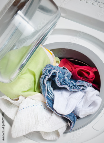 Photo: low angle view washing machine full of colorful clothes low angle view washing machine full of colorful clothes