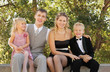 Happy family wearing holiday clothes sit and smile