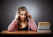 Photo: Unhappy schoolgirl with a stack of books Unhappy schoolgirl with a stack of books