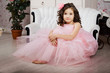 Girl in the nursery in pink dress