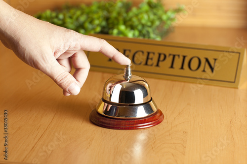 Photo: Hand of a man using a hotel bell Hand of a man using a hotel bell