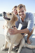 Smiling couple with dog on beach