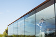 Businessman with paperwork talking on cell phone in office window