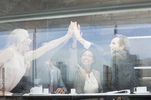 Photo: Business people joining hands in conference room Business people joining hands in conference room