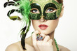 The beautiful young woman in a green mysterious venetian mask The beautiful young woman in a green mysterious venetian mask