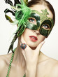 The beautiful young woman in a green mysterious venetian mask The beautiful young woman in a green mysterious venetian mask