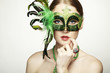 The beautiful young woman in a green mysterious venetian mask The beautiful young woman in a green mysterious venetian mask
