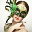 The beautiful young woman in a green mysterious venetian mask
