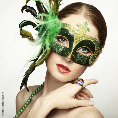 Photo: The beautiful young woman in a green mysterious venetian mask The beautiful young woman in a green mysterious venetian mask
