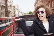 Photo : Portrait of exuberant woman wearing British flag sunglasses and riding double decker bus in London Portrait of exuberant woman wearing British flag sunglasses and riding double decker bus in London