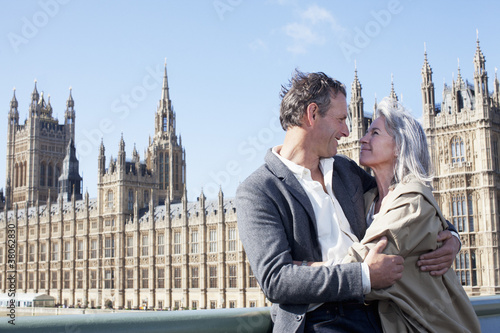 Photo: Happy couple hugging in front of Parliament Buildings in London Happy couple hugging in front of Parliament Buildings in London