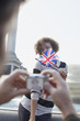 Man with digital camera photographing woman with British flag in front of fountain