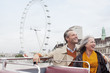 Happy couple riding double decker bus in London