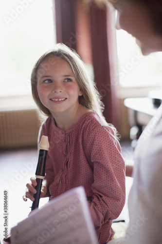 Photo: Grandmother with sheet music watching granddaughter practice on recorder Grandmother with sheet music watching granddaughter practice on recorder