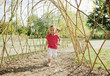 Smiling girl running under bare arbor in park