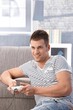 Young man playing video game at home