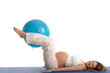 pregnant woman practicing yoga with blue ball