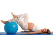 pregnant woman practicing yoga with blue ball
