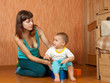 Mom puts  baby on  potty