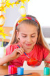 girl paints easter eggs