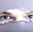 Photo: Augen starren durch Papierloch Augen starren durch Papierloch