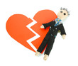 Voodoo doll boy-groom on the broken heart isolated on white