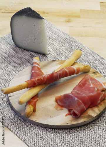 Photo: Appetizer with Parma ham on breadstick and cheese slice Appetizer with Parma ham on breadstick and cheese slice