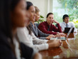 businesspeople talking in meeting room and man smiling