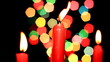 Three red candles on background of the color lights