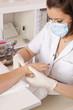 im Nagelstudio - Hand wird nach Behandlung eingecremt