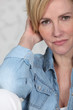 Closeup of a woman in her late thirties wearing a denim shirt