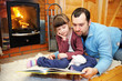 Photo: Father and daughter reading in front of fireplace Father and daughter reading in front of fireplace