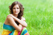 Young beautiful woman sitting on grass