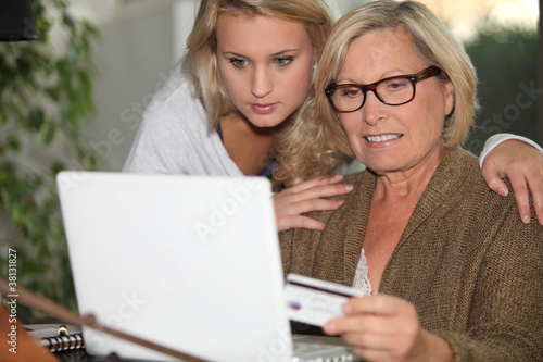 Photo: Senior woman and young girl in front of a laptop Senior woman and young girl in front of a laptop