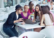 Cheerful friends browsing internet in a restaurant
