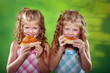 Two girls eating pizza on the green background