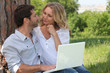 Couple with a laptop outside