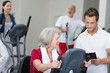 seniorin mit trainer im fitnessstudio