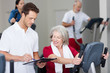 trainer berät seniorin im sportstudio