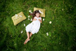 little girl resting on soft pillow in fresh spring grass