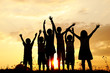 Silhouette, group of happy children playing on meadow,
