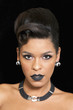 Gorgeous woman with black lipstick posing against black background