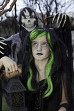 Photo: Little witch holding lantern with boy standing behind wearing grim reaper costume Little witch holding lantern with boy standing behind wearing grim reaper costume