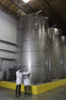 Full-length of factory workers having discussion at bottling plant