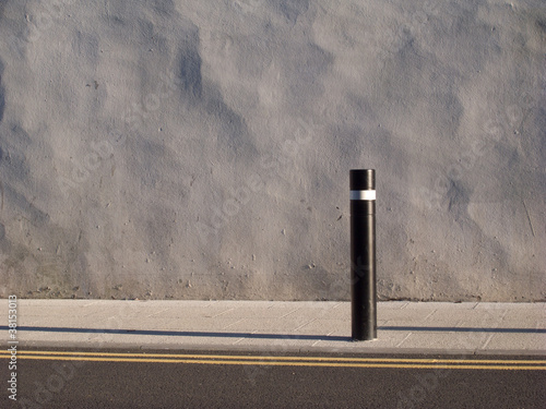 Photo: Wall, post, pavement. Wall, post, pavement.