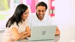 Young Ethnic Couple Online with Wireless Laptop