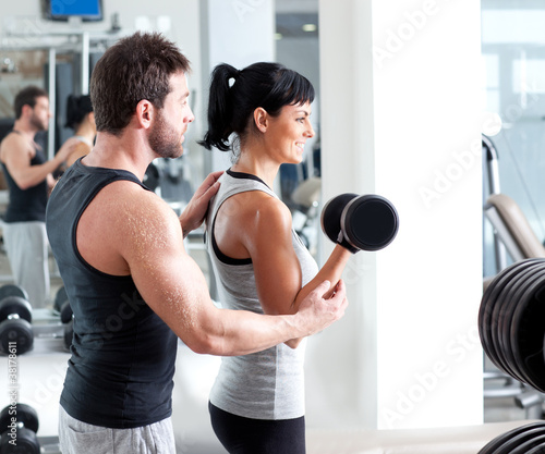 Photo: gym woman personal trainer with weight training gym woman personal trainer with weight training