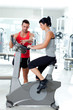 woman on stationary bicycle with personal trainer woman on stationary bicycle with personal trainer