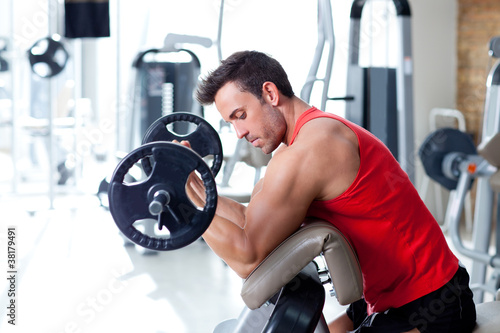 Photo: man with weight training equipment on sport gym man with weight training equipment on sport gym