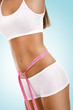 stomach, weight - woman measuring her waist on blue background stomach, weight - woman measuring her waist on blue background